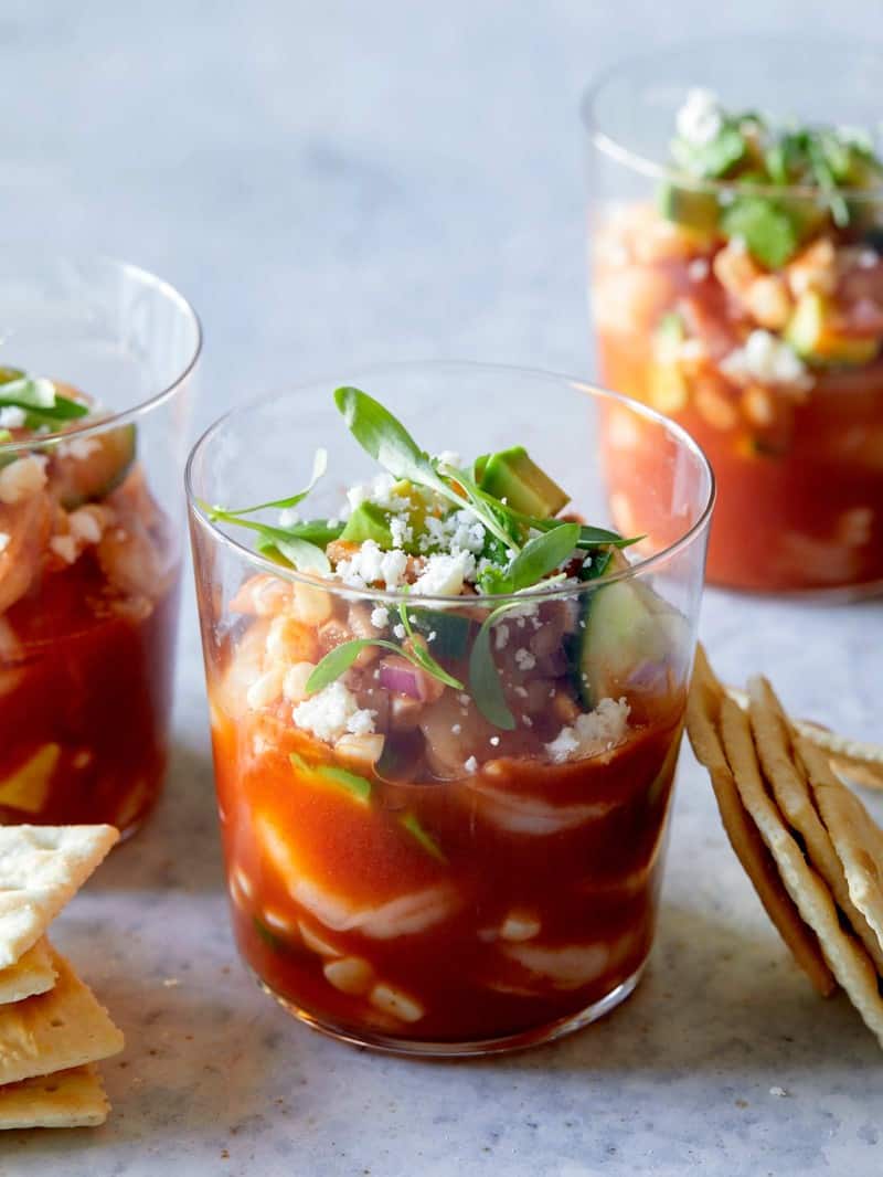 A close up of glasses of Mexican shrimp cocktails with saltine crackers.